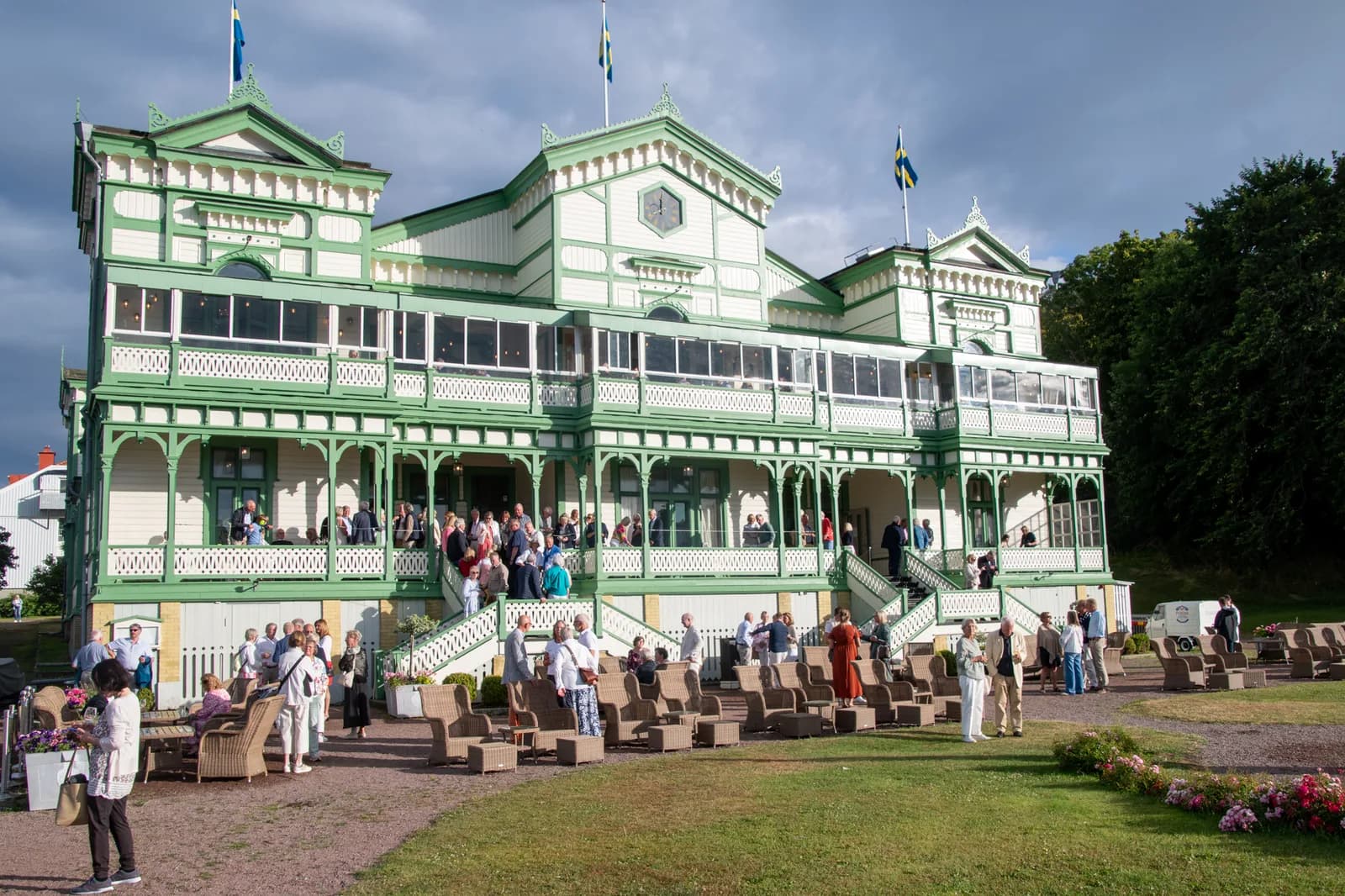 Societetshuset on Marstrand in evening light, with the concert audience gathered outside the steps