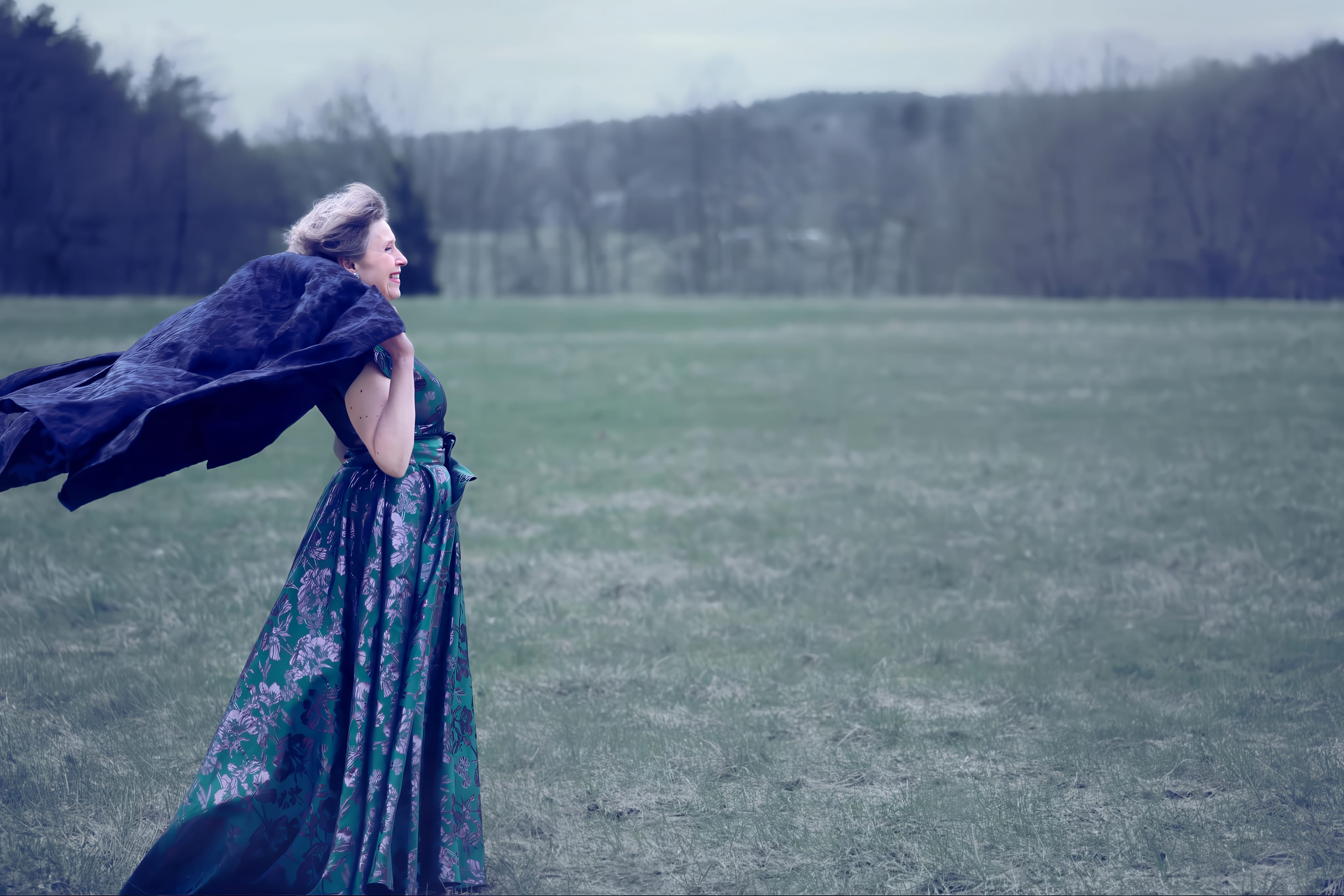 Ann-Christine Larsson, operasopran, sjunger utomhus med vajande cape. Foto: Emelie Kroon.